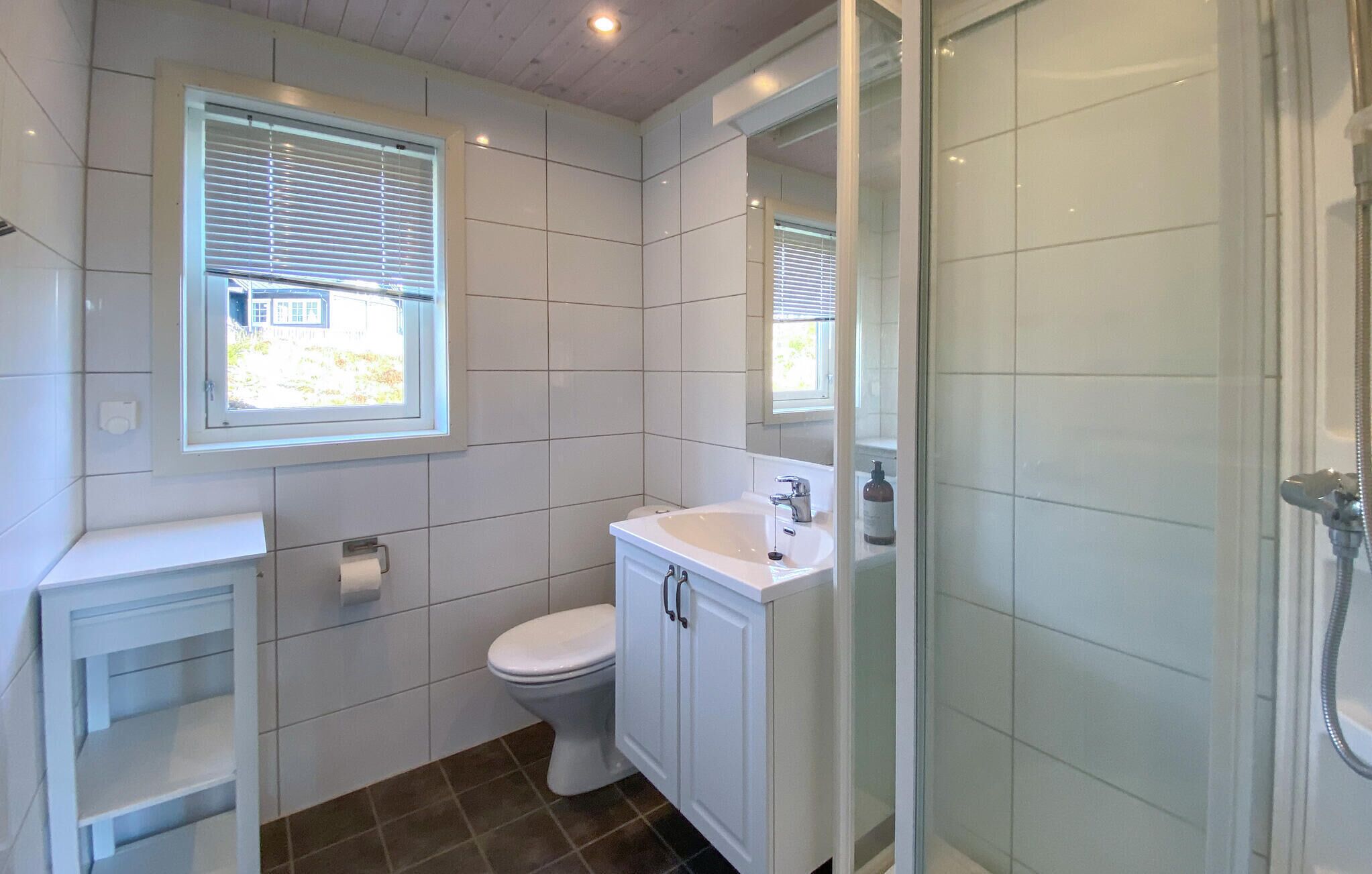A bathroom with a toilet, sink, and shower.