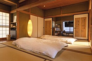 Een traditionele Japanse kamer met tatami vloerbedekking, een lage tafel en schuifdeuren met kalligrafie.