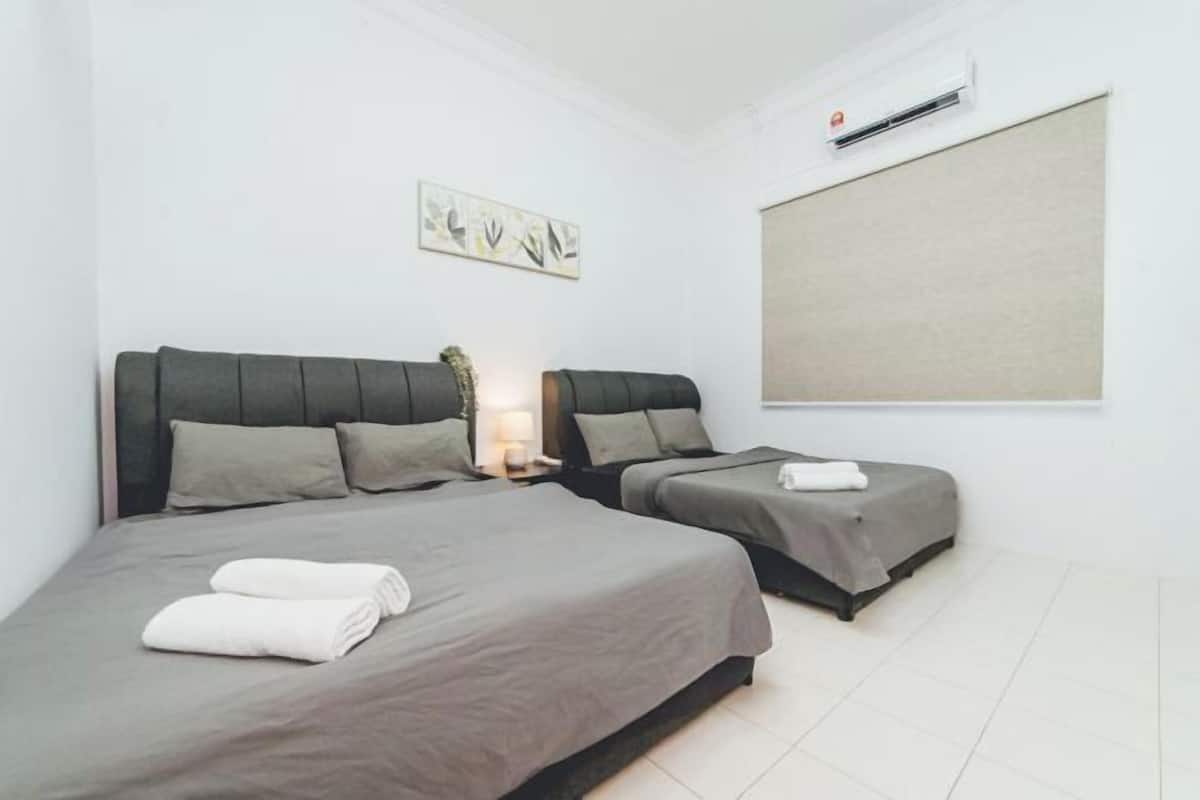 A hotel room with two beds, a wall-mounted air conditioner, and a large window.