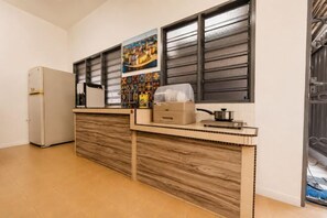 A kitchen with a built-in refrigerator, a wooden countertop, and a window with blinds. - Batu Pahat Sri Jaya Villa 4BR 18pax (Simpang Kanan)