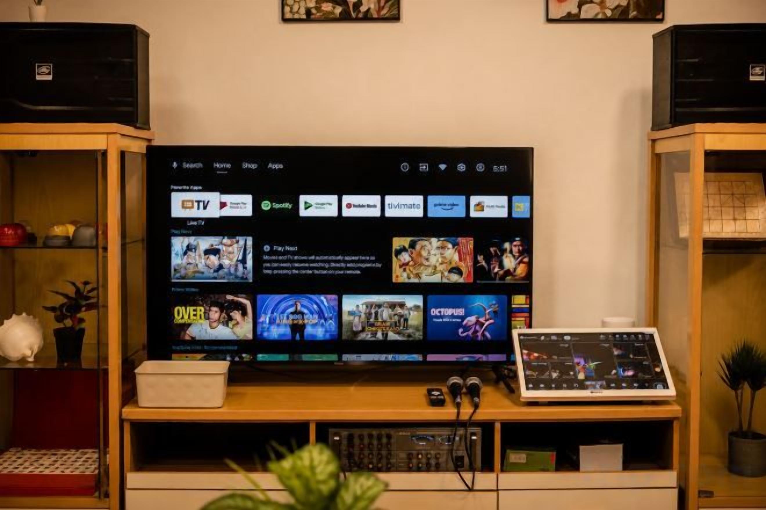 Ein Fernseher auf einem Holzständer, dessen digitale Benutzeroberfläche verschiedene Streaming-Dienste anzeigt.