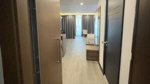 A hallway leading to a bedroom with a bed, a chair, and a desk. - Sea side apartment in "Batumi View" (Batumi)