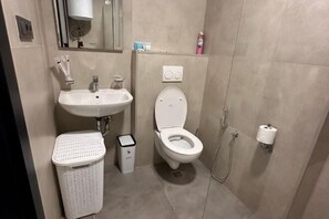 A bathroom with a sink, toilet, and shower. - Sea side apartment in "Batumi View" (Batumi)