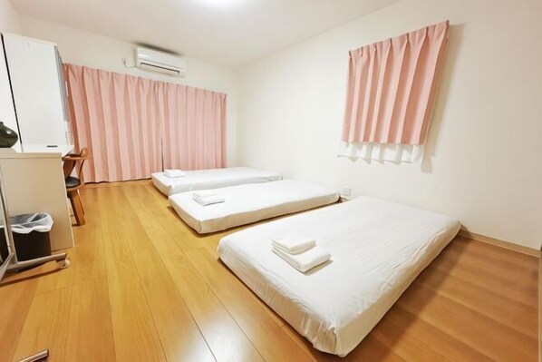 A room with two beds, a desk, a chair, and a wardrobe. - Guesthouse Atelier Ten (Osaka)