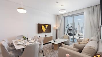 Departamento de lujo, balcón, vista a la ciudad | Área de sala de estar | Smart TV de 65 pulgadas con canales vía satélite