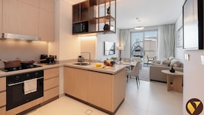 Una cocina moderna con una isla central, un rincón de comedor con sofá y vistas a la ciudad.
