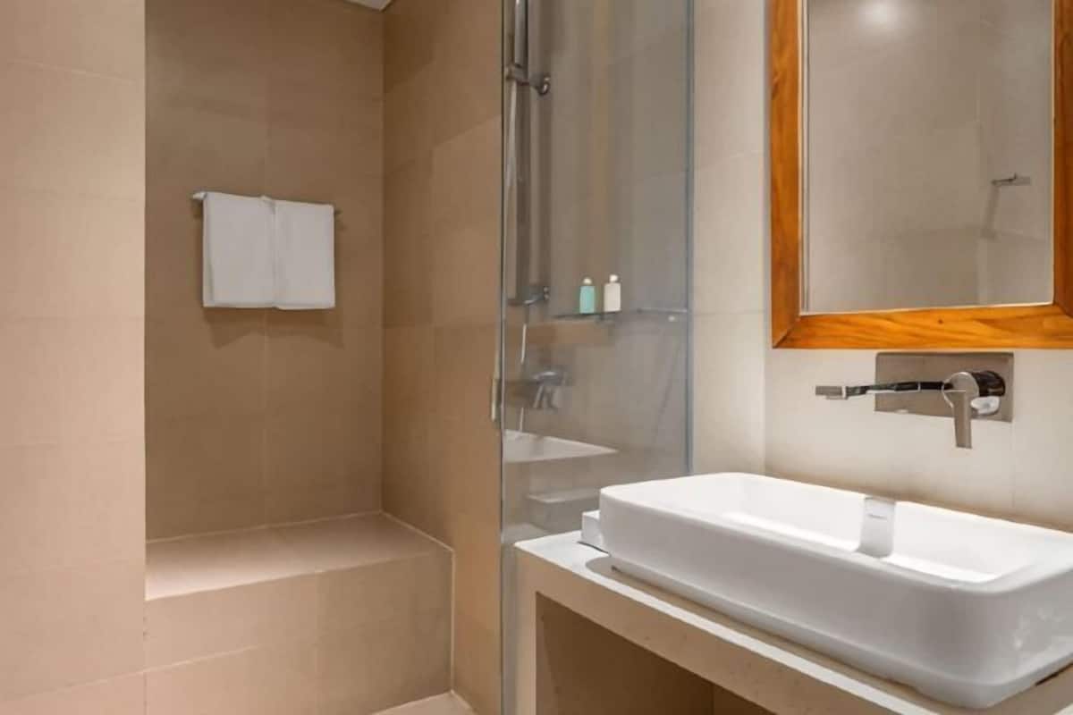 Un baño con bañera, ducha, lavabo y espejo.