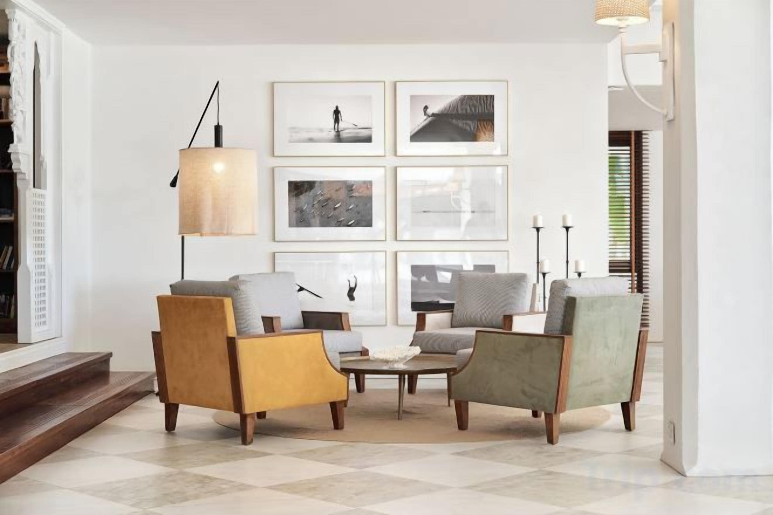 A living room with a checkered floor, a coffee table, and three armchairs.
