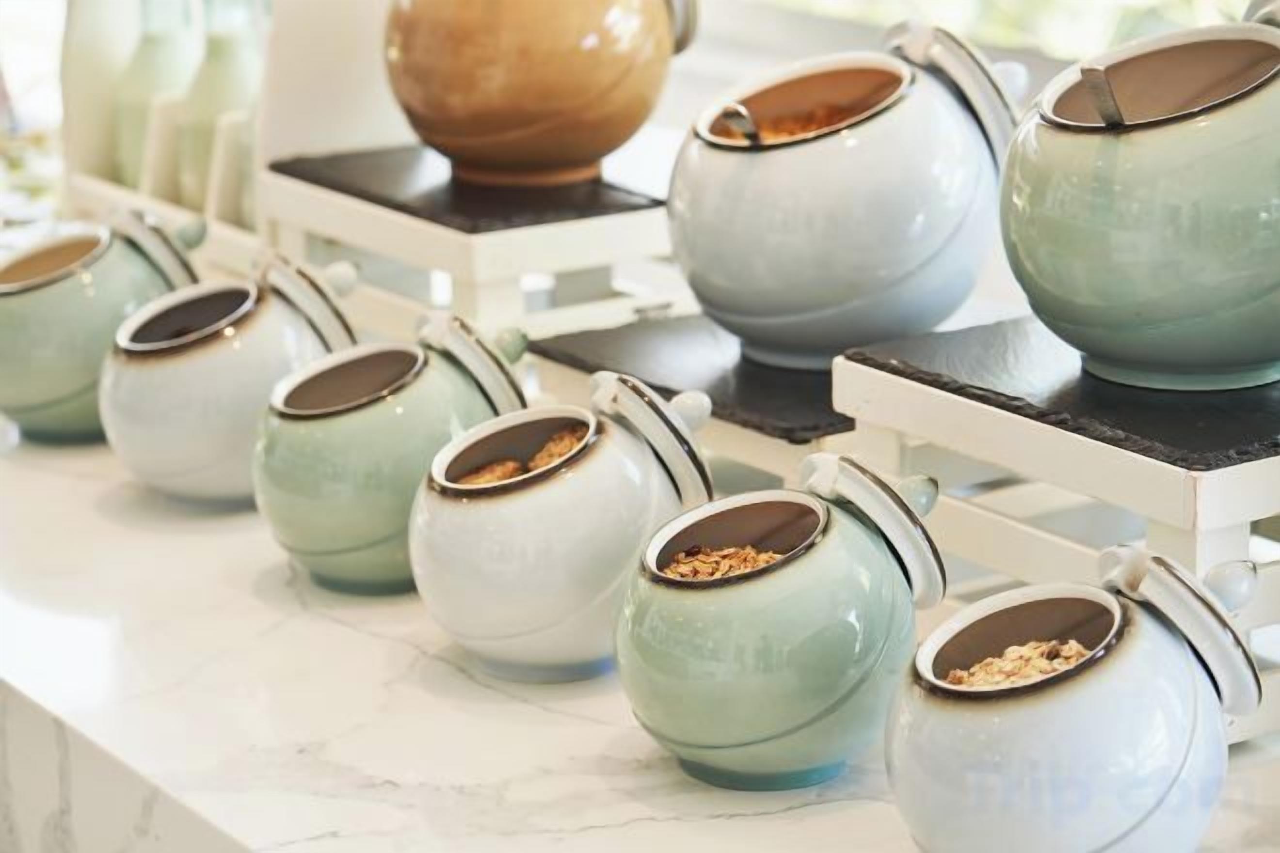 A row of ceramic mugs on a white countertop.