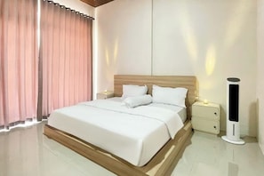 A modern hotel room with a large bed, bedside tables, and a standing lamp. - Rejeng Bungalow near Gangga Waterfall Lombok (Genggelang)