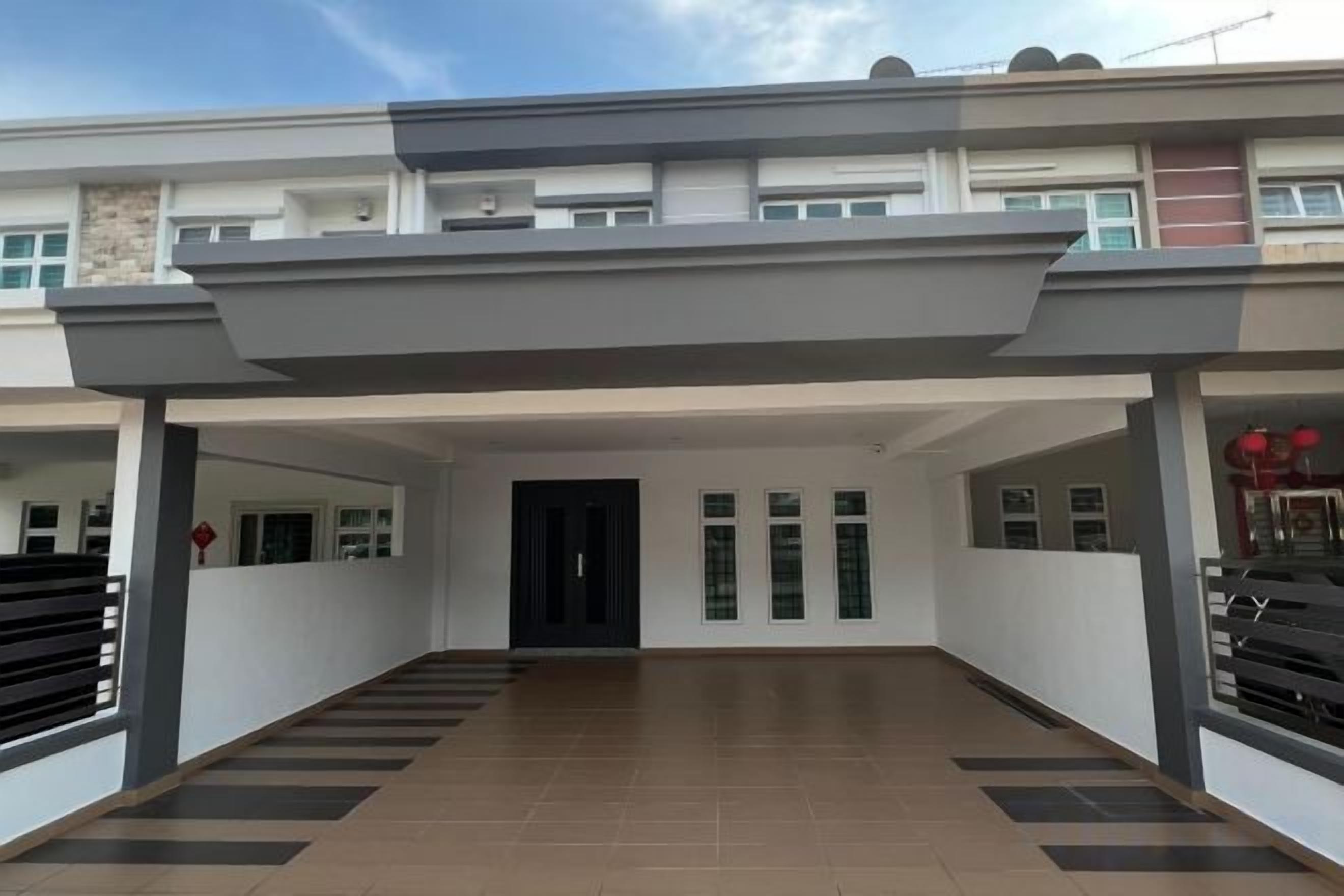 A modern multi-story building with a covered entrance area, a flat roof, and a tiled floor.