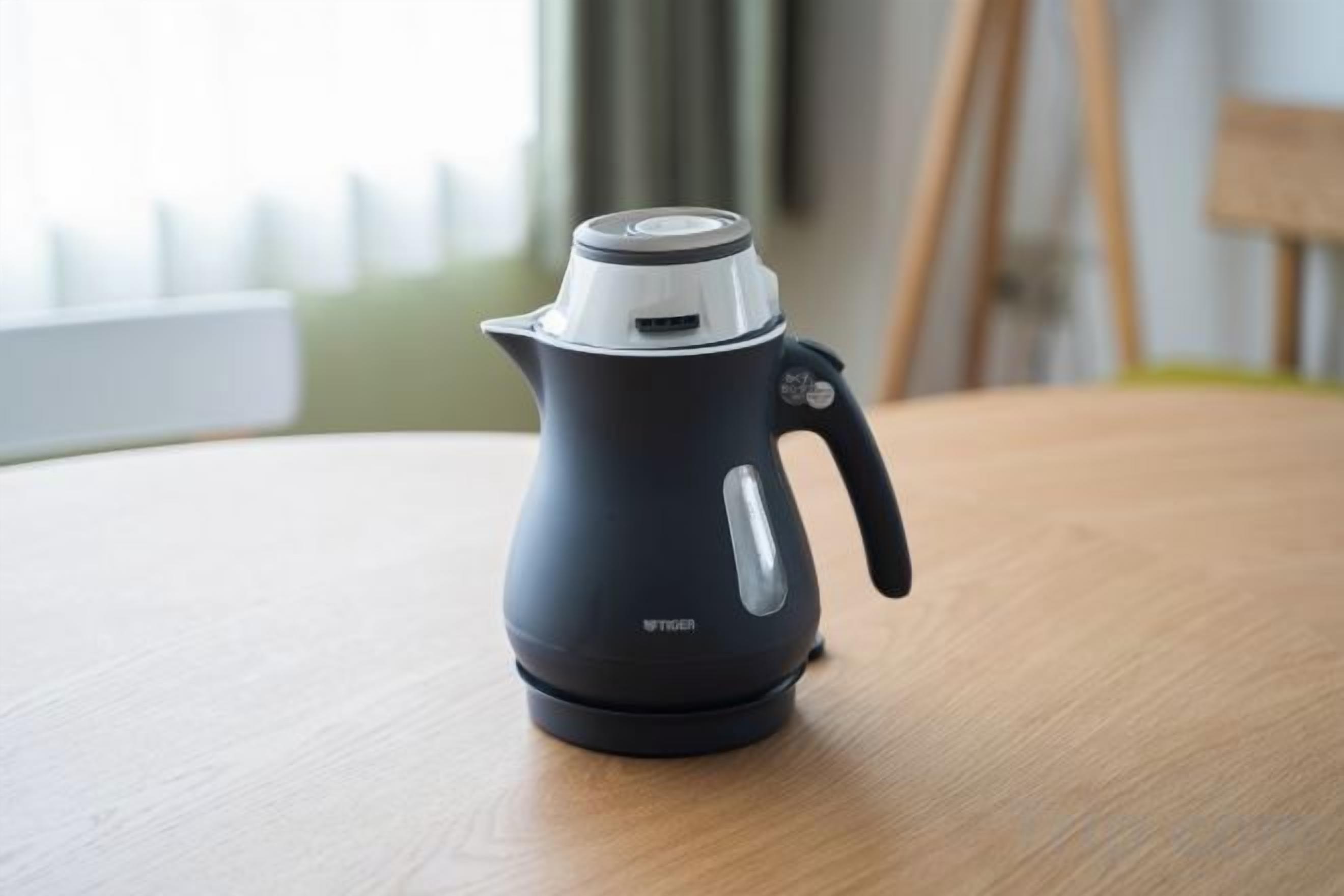 A black electric kettle on a wooden table.