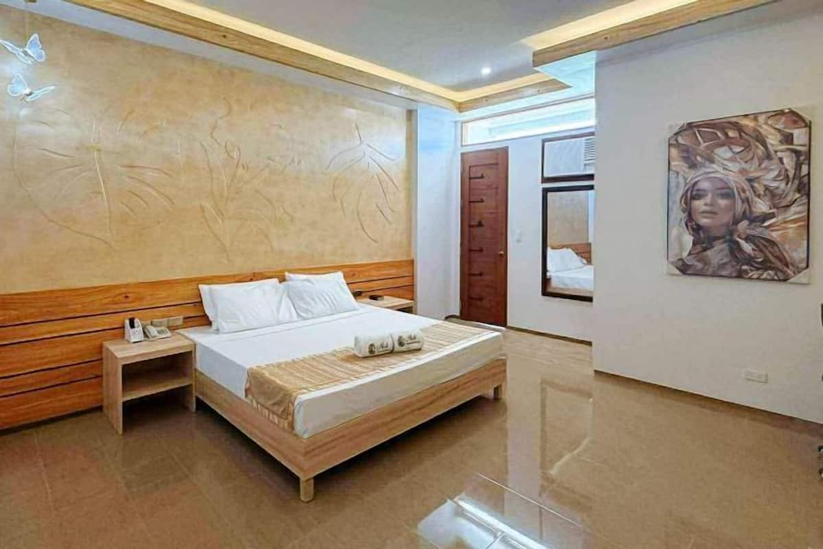 A bedroom with a wooden bed, nightstands, a mirror, and a wall with a floral design.