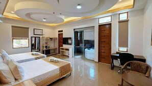 A hotel room with two beds, a desk, a chair, a wardrobe, and a bathroom. - RedDoorz Plus @ Nick Hotel Guimba (Guimba)