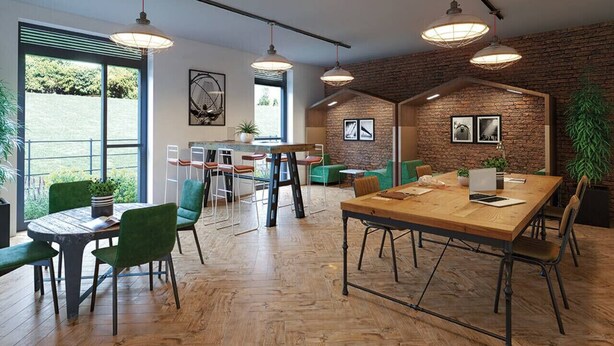 A modern office space with a large wooden table, green chairs, and hanging pendant lights. - Belgrave Village | Central Apartment (Balsall Heath)