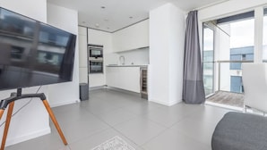 Um apartamento moderno com cozinha, área de refeições e varanda.