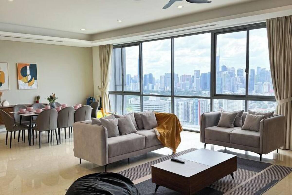 Un salon moderne comprenant deux canapés, une table basse et un coin repas avec des chaises et une table.