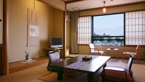 A traditional Japanese room with tatami flooring, a low table, and chairs. - Hanaakarinoyado Tsukinoike (Kaminoyama)