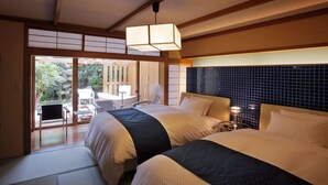 A hotel room with two beds, a sliding glass door to a balcony, and a traditional Japanese-style lamp. - Hanaakarinoyado Tsukinoike (Kaminoyama)