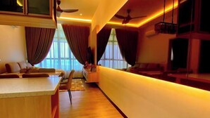 A modern living room with a wooden floor, a sofa set, a coffee table, and a TV. - FZ Homestay @ Putrajaya P5 : Luxury & scenic stay (Putrajaya)