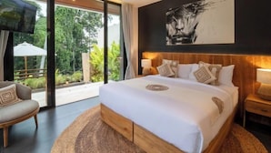 Une chambre moderne avec un grand lit, une télévision et une vue sur la verdure.
