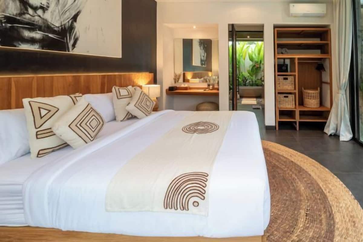 Een hotelkamer met een groot bed, een bureau en een kledingkast.