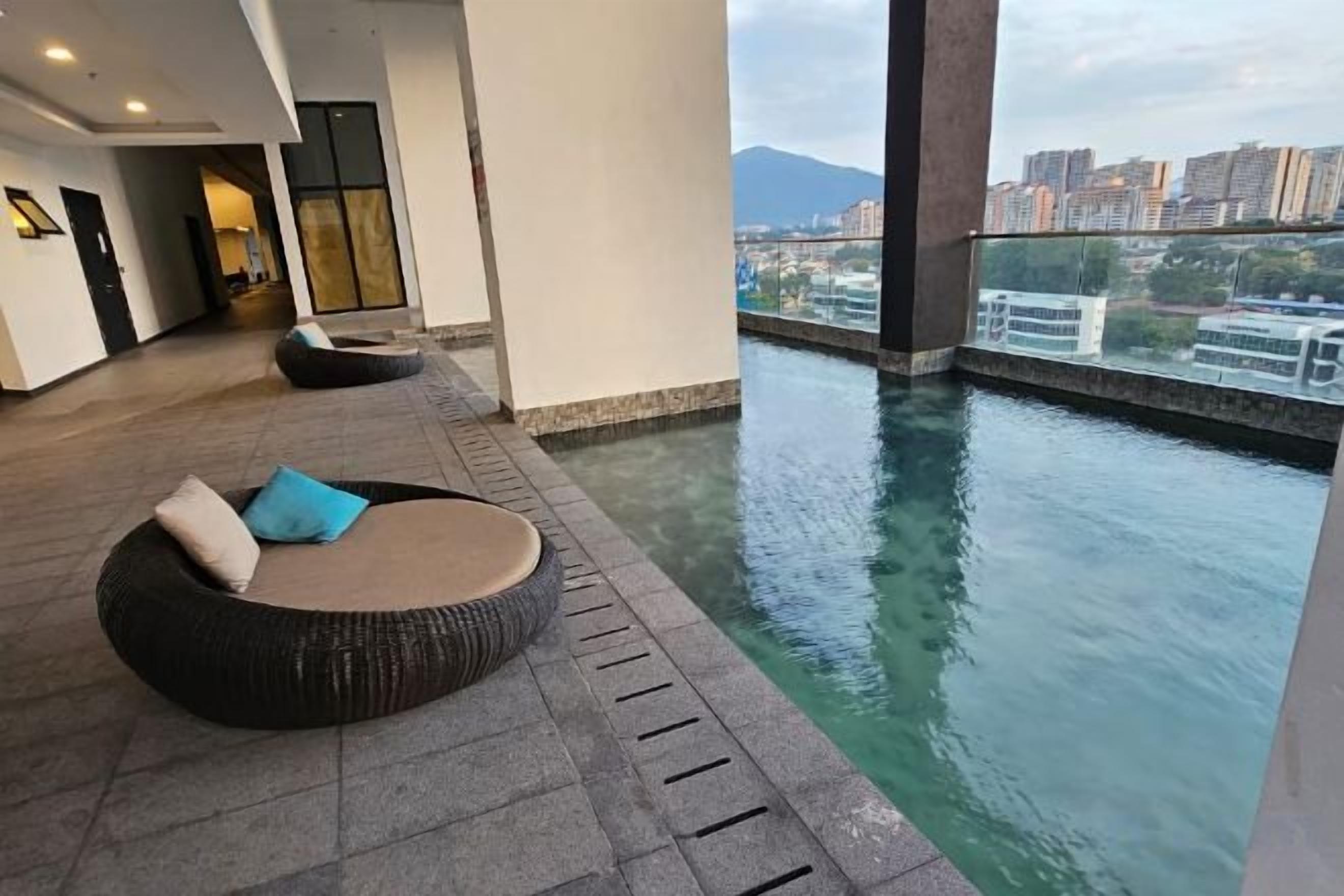 A rooftop pool area with a seating area and a view of the cityscape.
