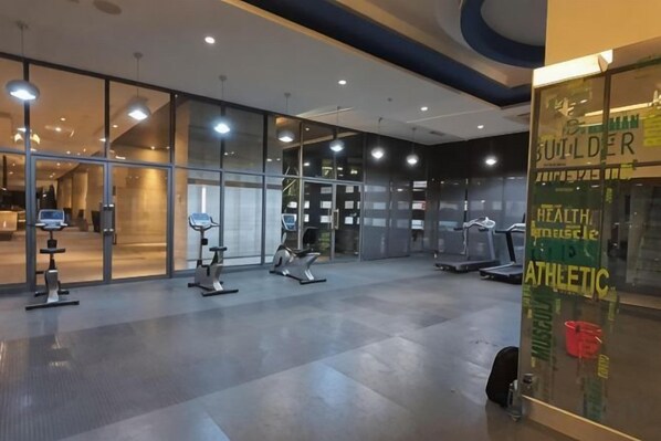 A gym with exercise equipment, a reception area, and a glass wall with a sign. - The Elements @ Ampang (Kuala Lumpur)