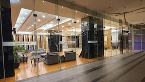 A modern hotel lobby with glass walls, a seating area, and a sign reading 'TOWER A1'. - The Elements @ Ampang (Kuala Lumpur)