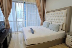 A hotel room with a large bed, curtains, a television, and a view of the city. - The Elements @ Ampang (Kuala Lumpur)