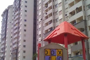 A high-rise residential building with balconies and a red-roofed structure with the letters 'DOX' visible. - Beautiful Suria Kipark Damansara 3R2B Apartment (Batu)