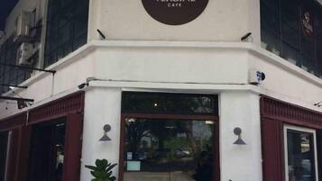 Exterior do Vergine Cafe, com uma placa chamativa acima da entrada.
