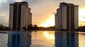 Una piscina con dos edificios altos al fondo.