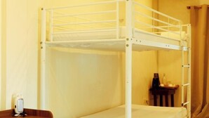 A bunk bed room with a wooden nightstand and a small table with a bottle and a cup. - Sunrise Beach Resort (Santa Fe)