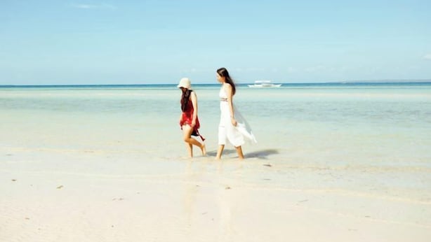Two people walking on a beach. - Sunrise Beach Resort (Santa Fe)
