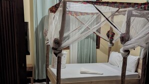 A room with a bed, a ceiling fan, and a door. - Kilimanjaroo Inn (Moshi)