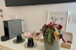 A kitchen counter with a coffee machine, a vase with a plant, a framed sign with 'Wifi' and a Wi-Fi symbol, and a box labeled 'Nespresso.' - Martinengo30 - Milano Metro M3 (Milan)