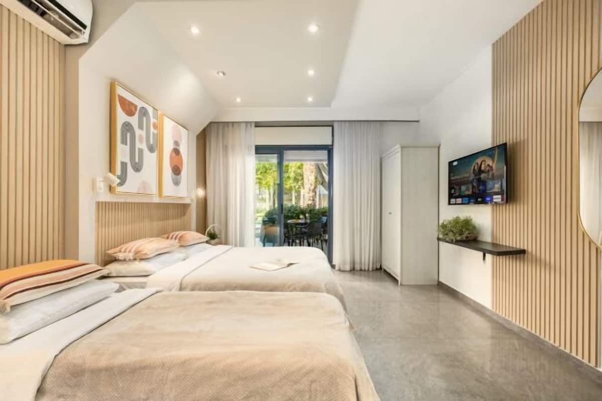 Une chambre d’hôtel moderne avec deux lits, une télévision et une vue sur l’extérieur.
