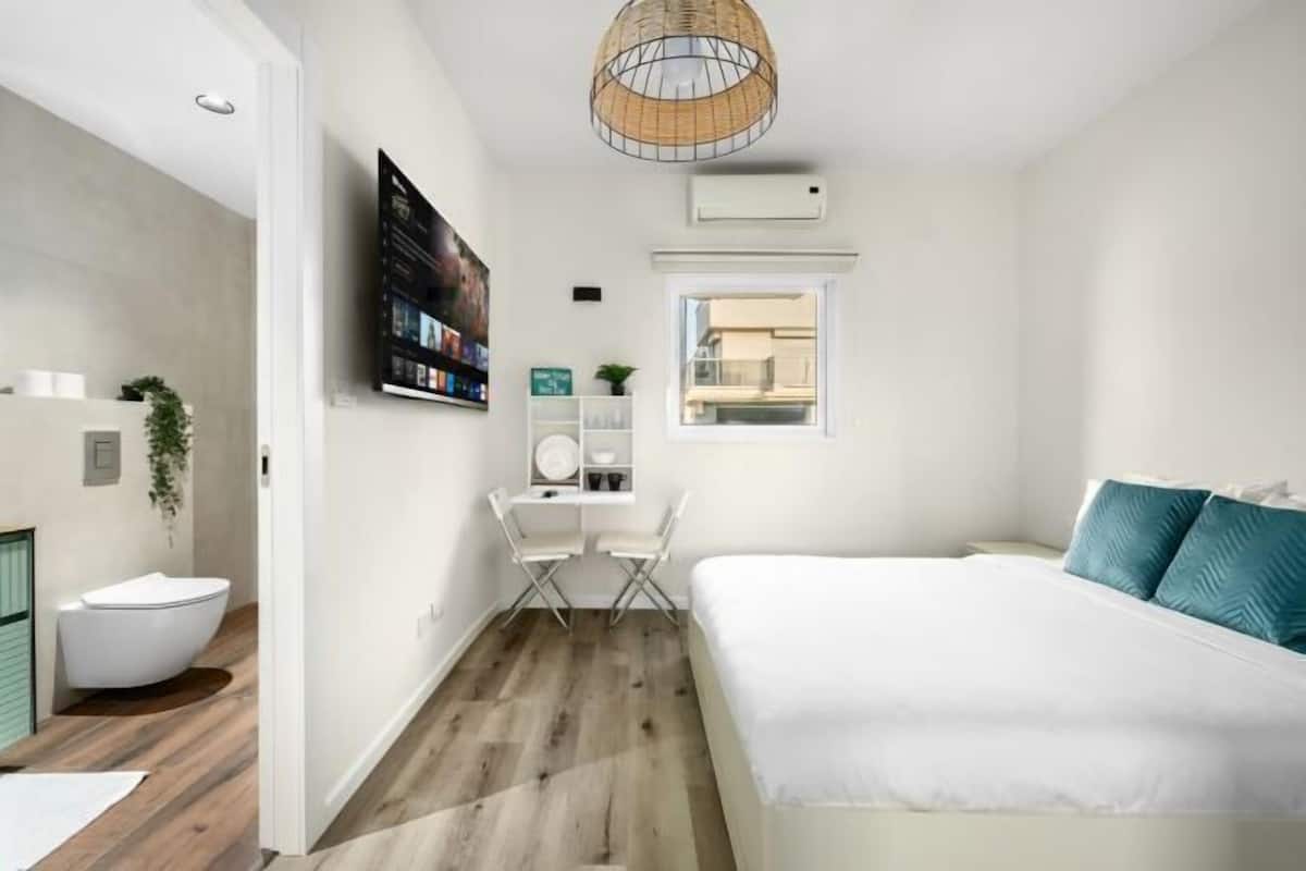 A modern bedroom with a bed, a desk, and a chair.