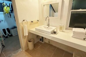 A bathroom with a white sink, mirror, and towel rack. - Yonna Yonna よんなよんな (Miyakojima)