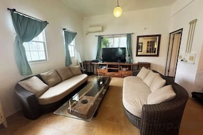 Una sala de estar con un sofá, una mesa de centro y una televisión.