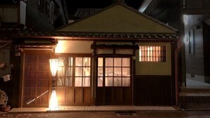 A traditional Japanese building with a wooden exterior, a tiled roof, and a lit entrance. - Ranjatai Premium (Nara)