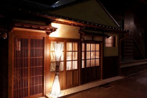 A traditional Japanese building with wooden doors and windows, a staircase, and a lantern. - Ranjatai Premium (Nara)