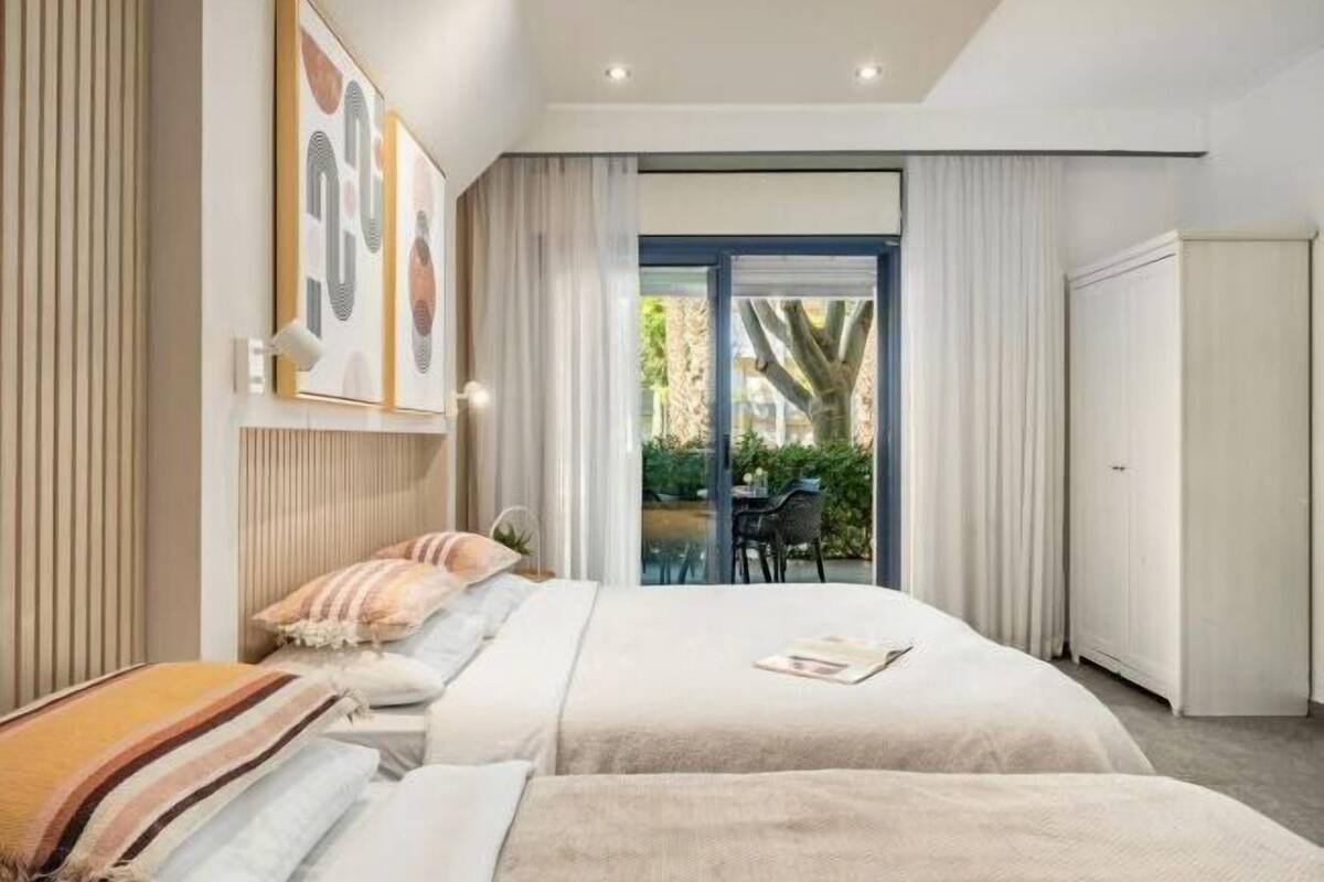 Un dormitorio moderno con una cama grande, un armario y vistas a un patio exterior.