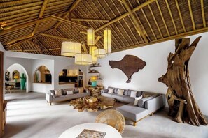 A spacious living area with a high ceiling, a large sofa set, and a dining table. - Villa La Canopee by BaliSuperHost (Bali)
