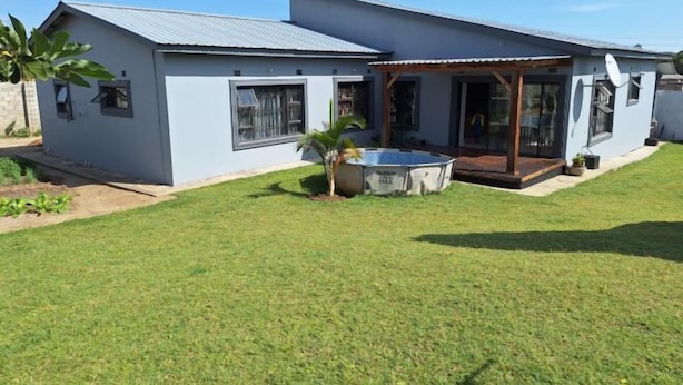A modern two-story house with a covered patio, a swimming pool, and a well-maintained lawn. - Chic Modern Escape (Lusaka)
