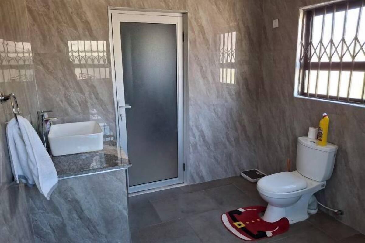 A bathroom with a toilet, sink, and shower area.