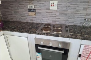 A kitchen with a granite countertop, stainless steel stove, and oven. - Chic Modern Escape (Lusaka)