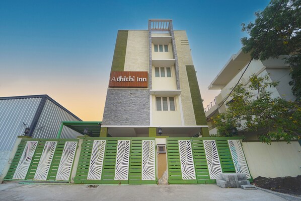 A multi-story building with a sign reading "Adhithi Inn" on the facade.