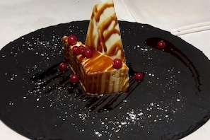 Un dessert su un piatto con salsa scura e bacche rosse.